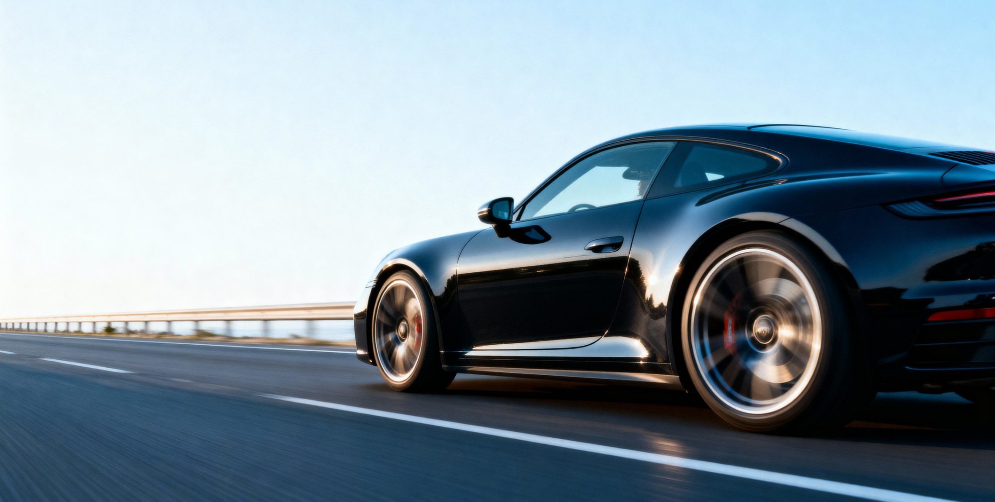Schwarzer Sportwagen in voller Fahrt auf der Autobahn
